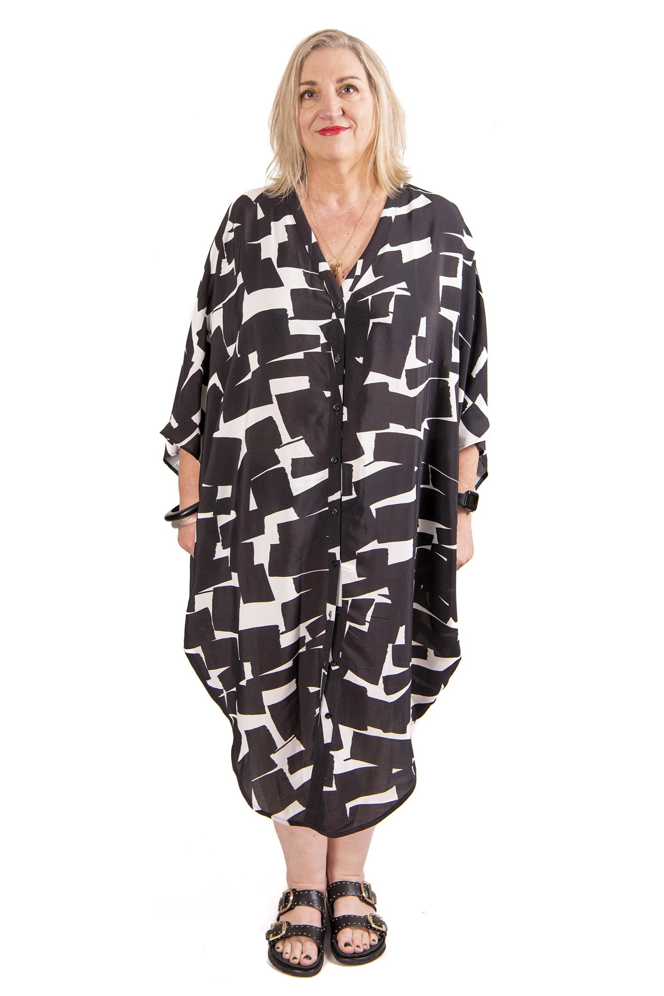 Woman wearing a black and white patterned kaftan on a white background