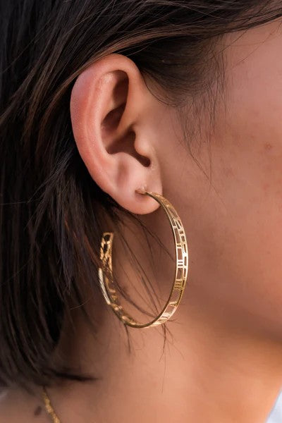 gold hoops earrings with map and clock details on ear