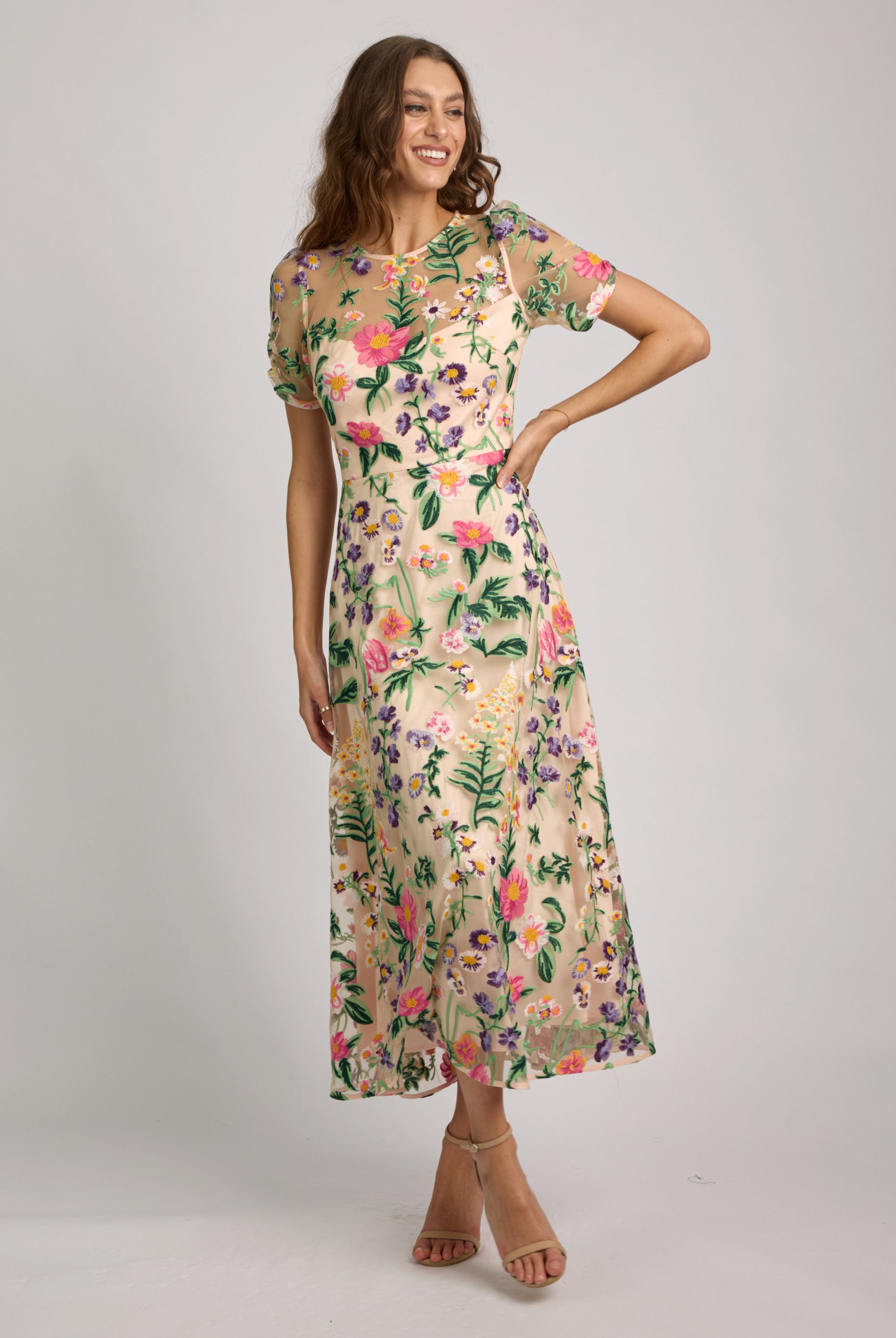 Woman wearing a floral dress against a plain background