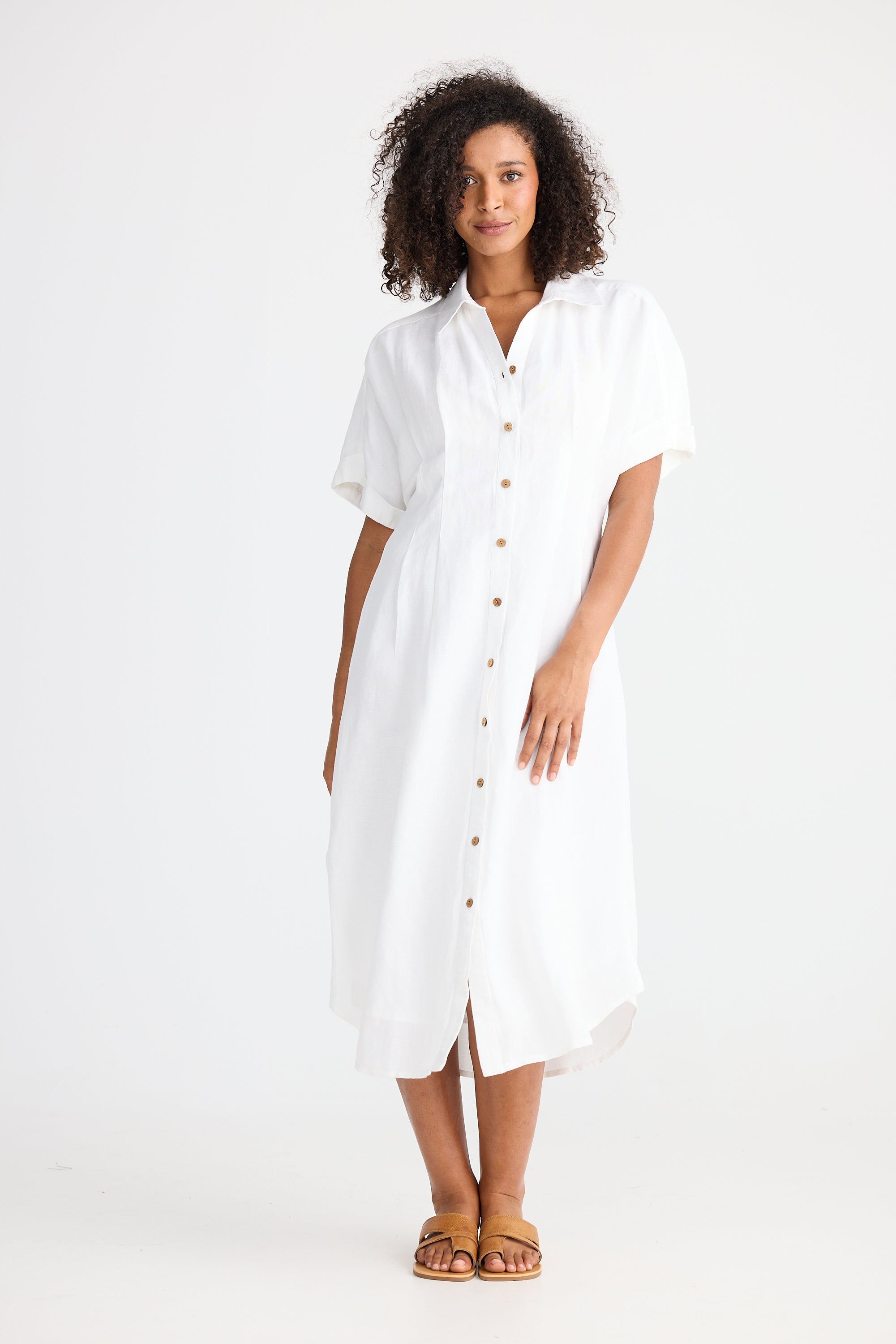 Woman wearing a white dress with a button-up front on a white background