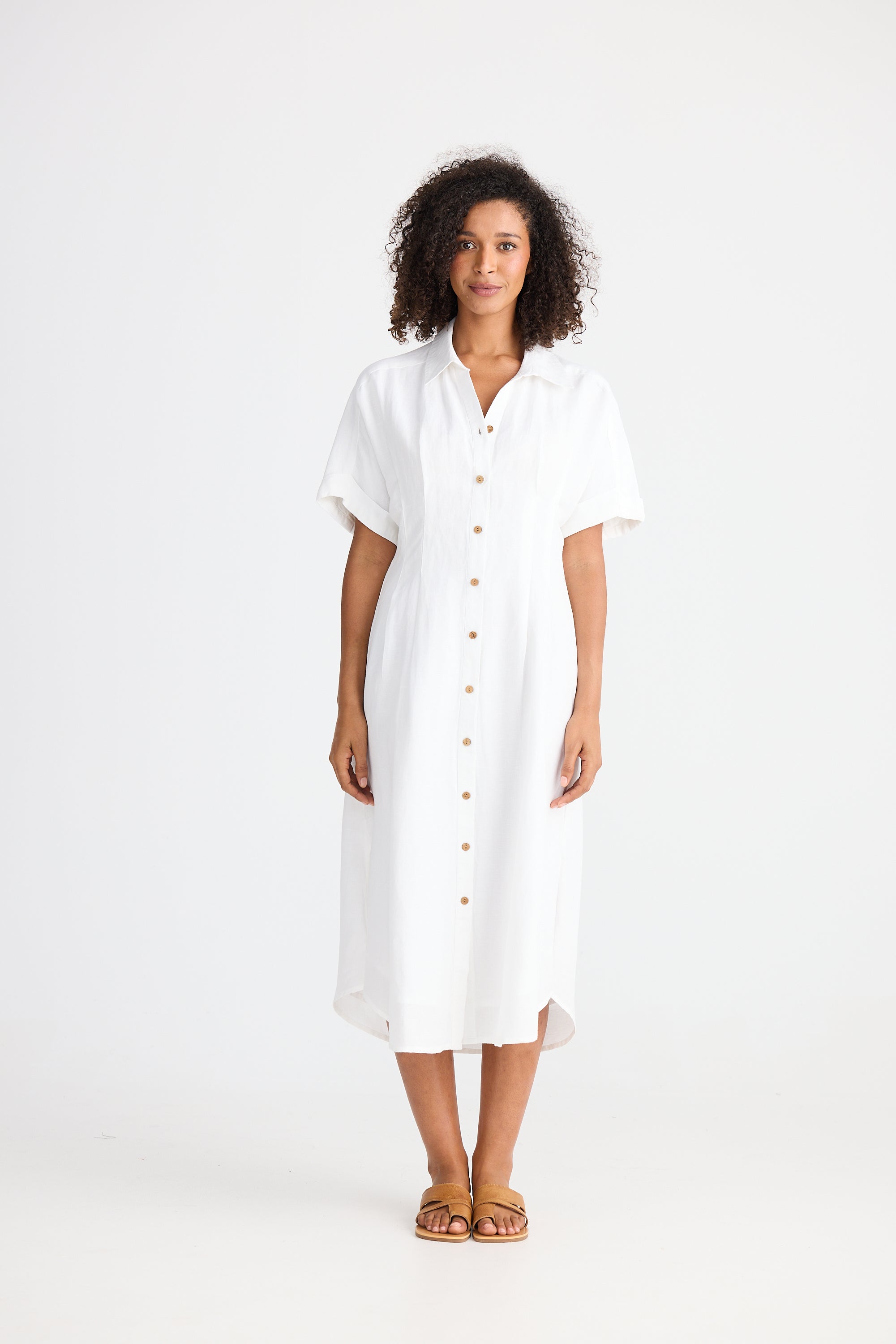Woman wearing a white dress with buttons on a white background