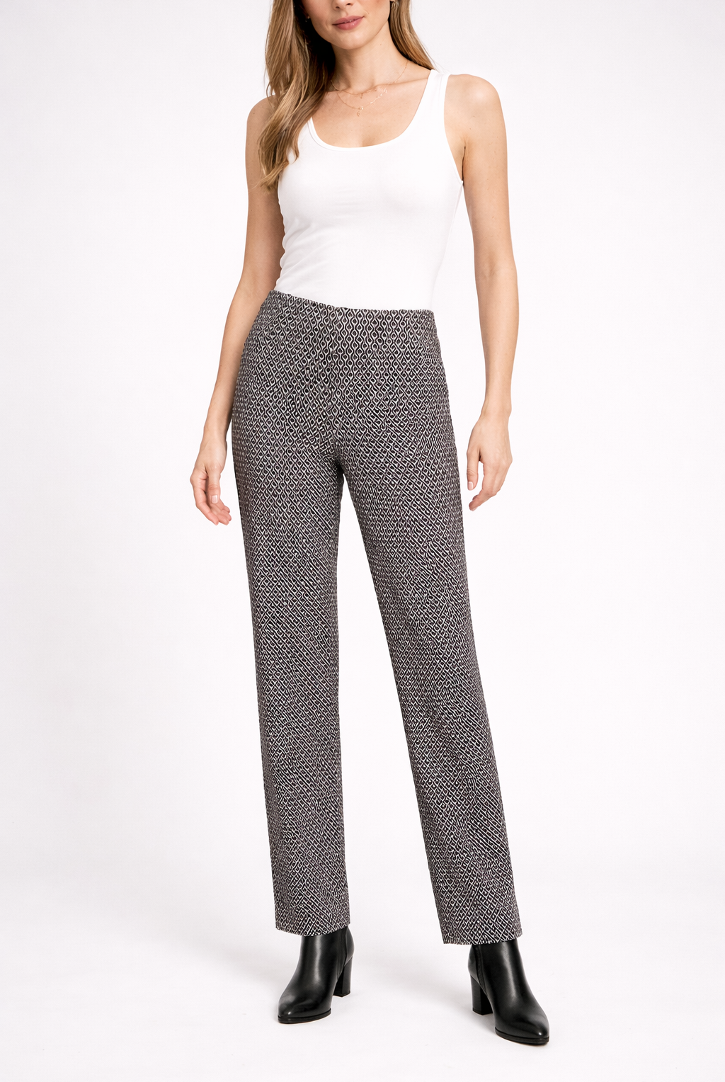 Woman wearing a white sleeveless top and patterned pants on a white background