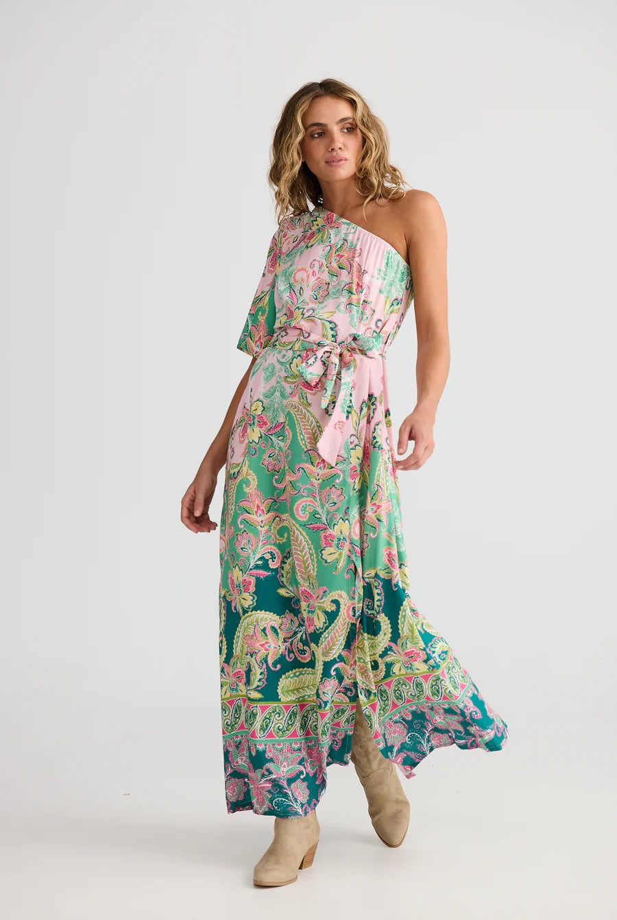Woman wearing a floral one-shoulder dress with a belt on a white background