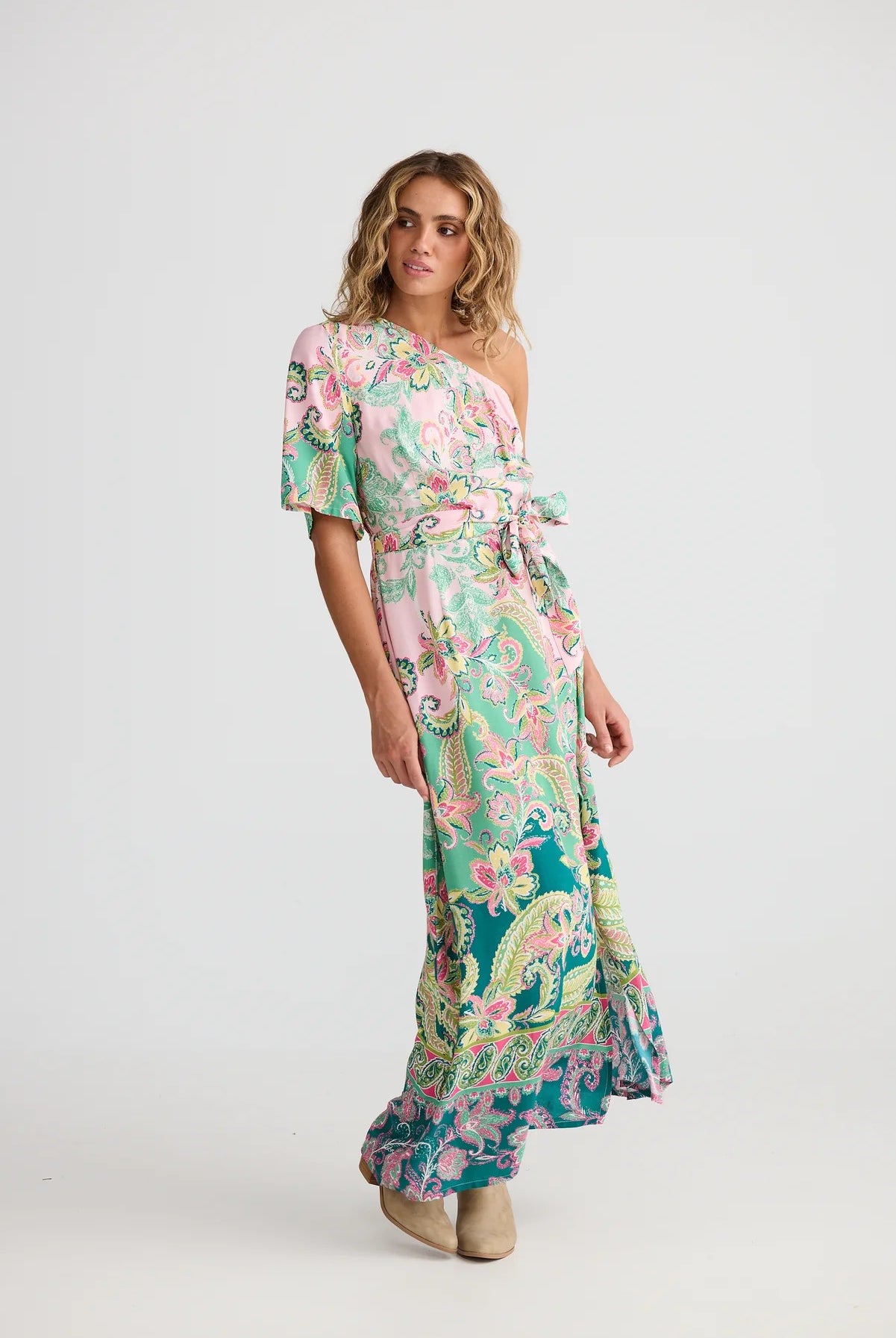 Woman wearing a floral one-shoulder dress on a white background