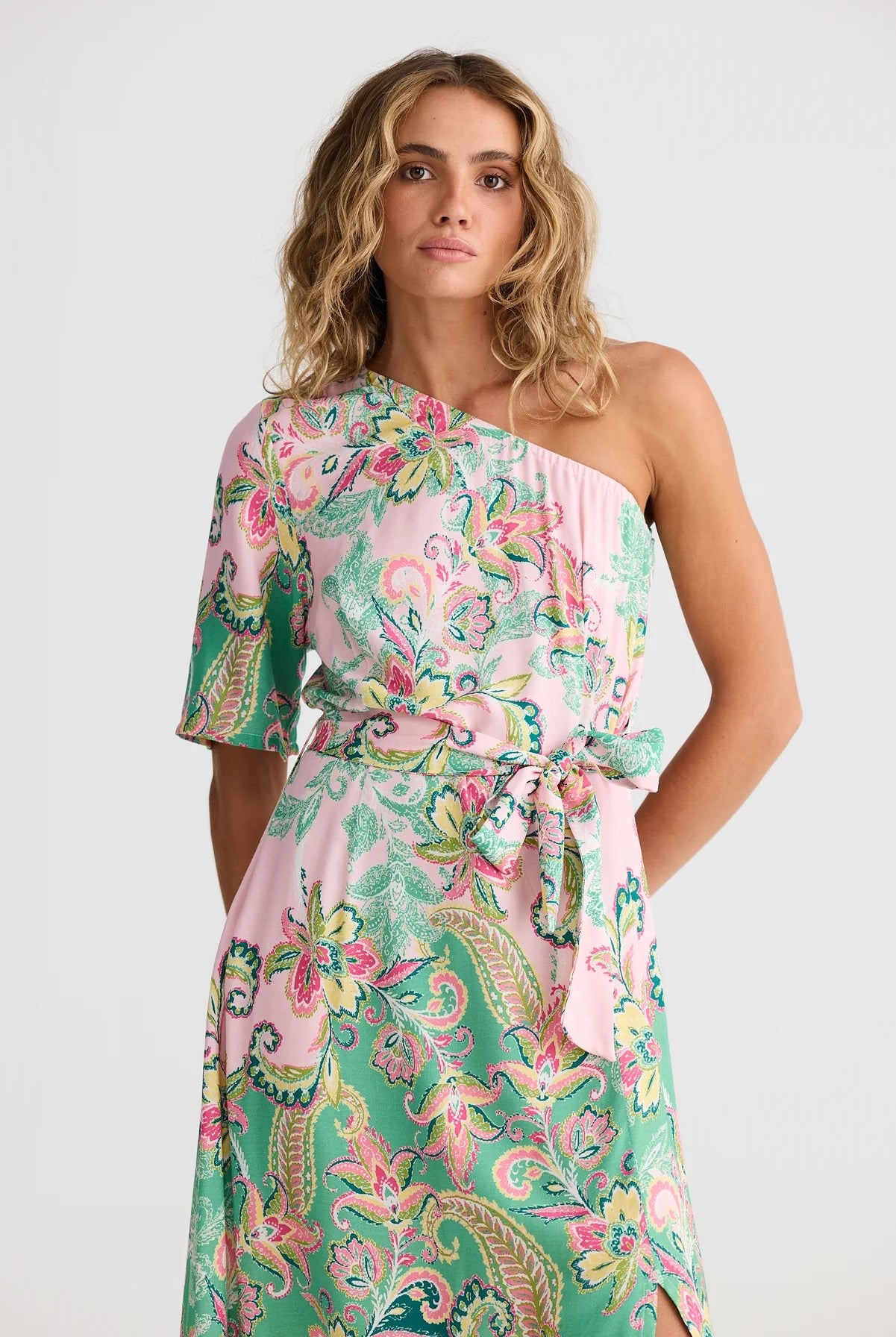 Woman wearing a floral one-shoulder dress on a white background