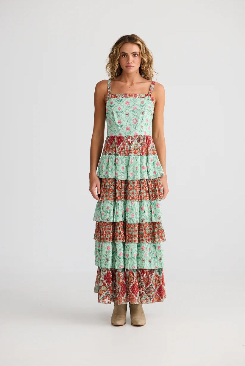 Woman wearing a tiered dress with a floral pattern on a white background