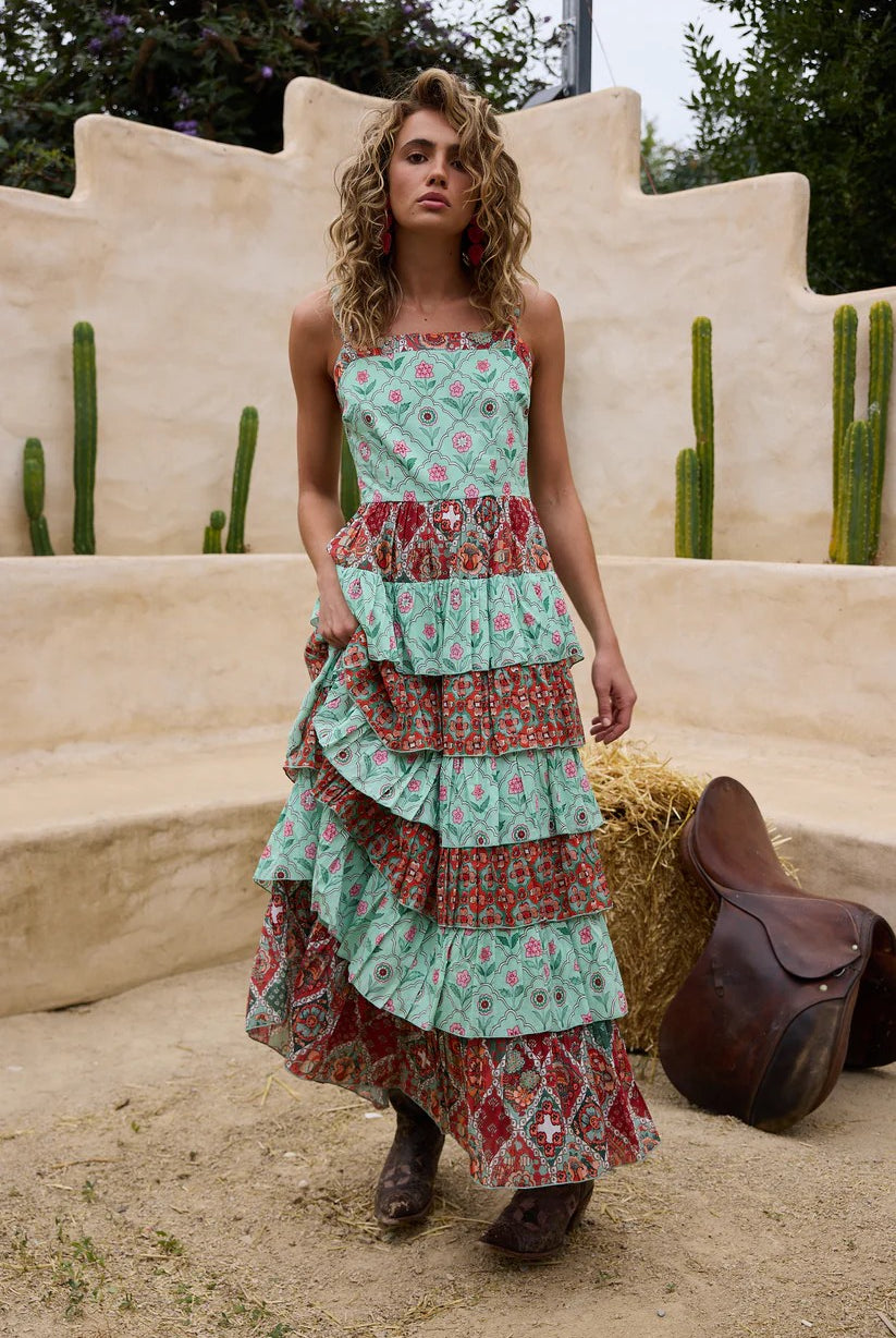 Woman wearing a layered dress with a desert landscape and cacti in the background