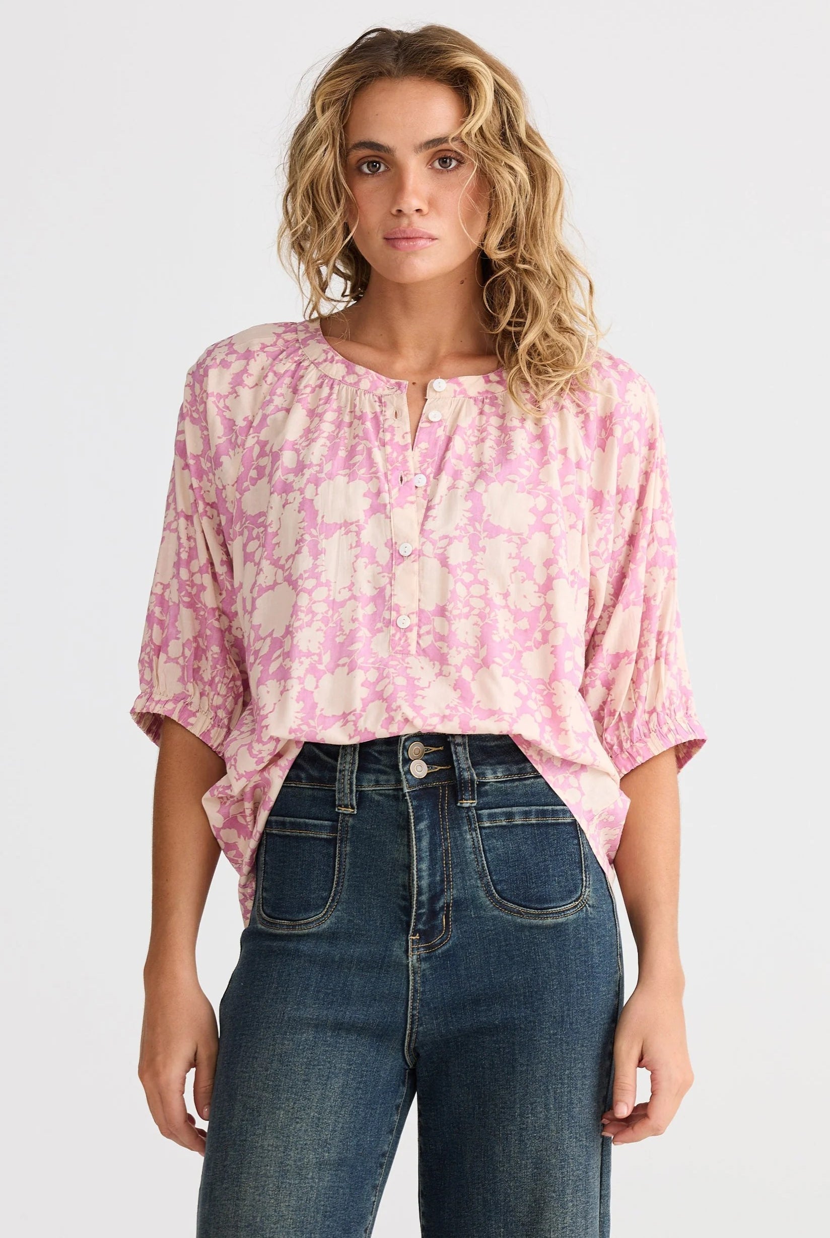 pink cream floral blouse and jeans worn by model