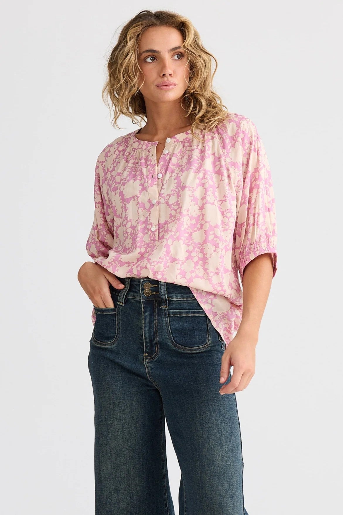 pink cream floral blouse and jeans worn by model