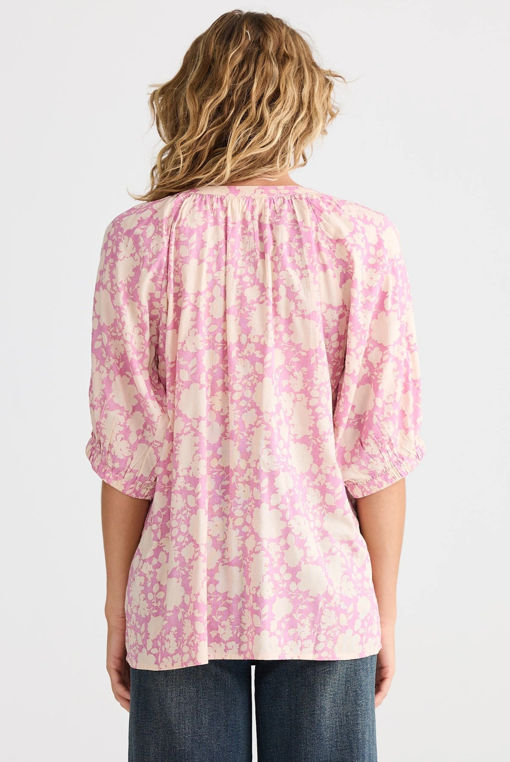 pink cream floral blouse and jeans worn by model back