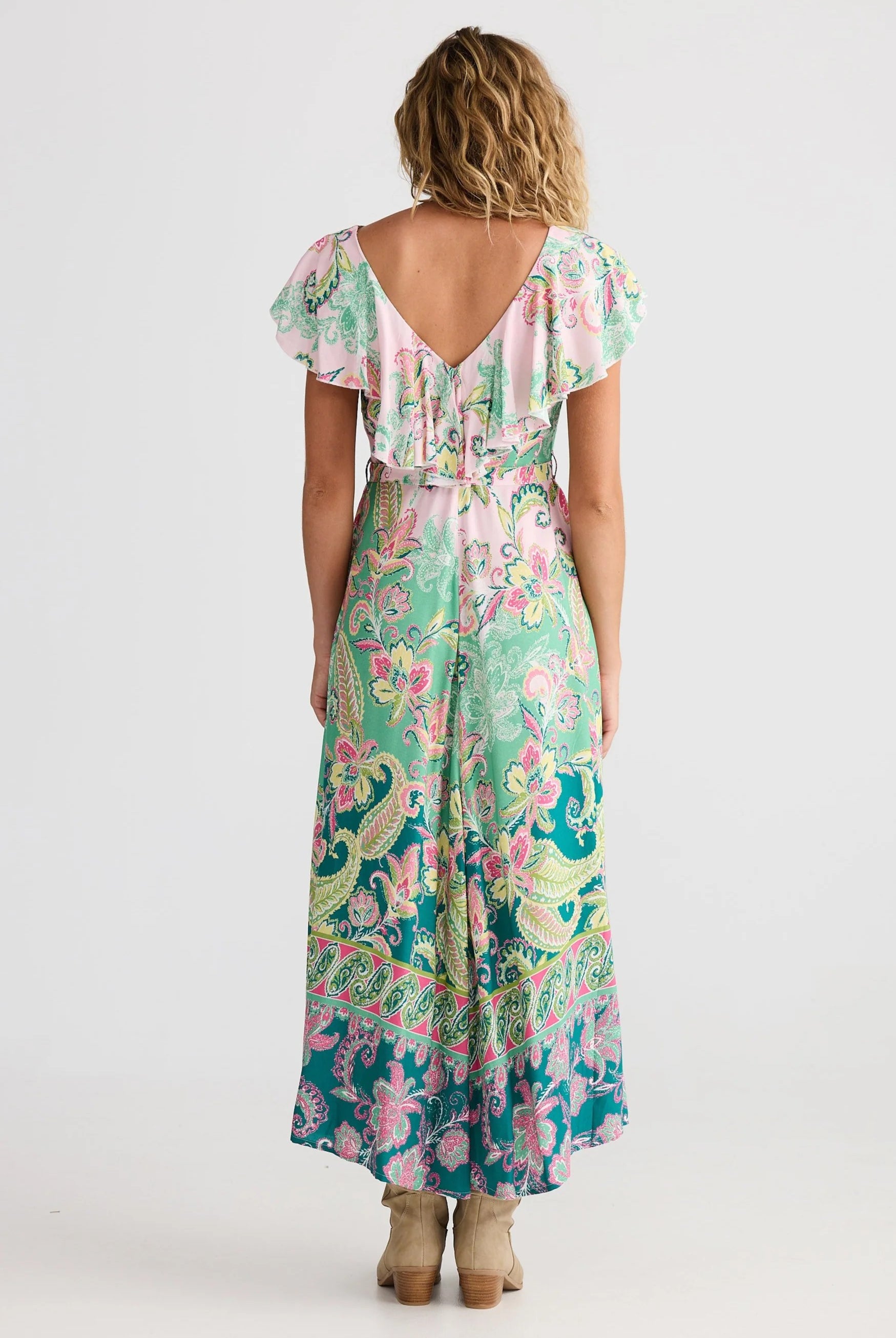 Woman wearing a floral dress with a white background back