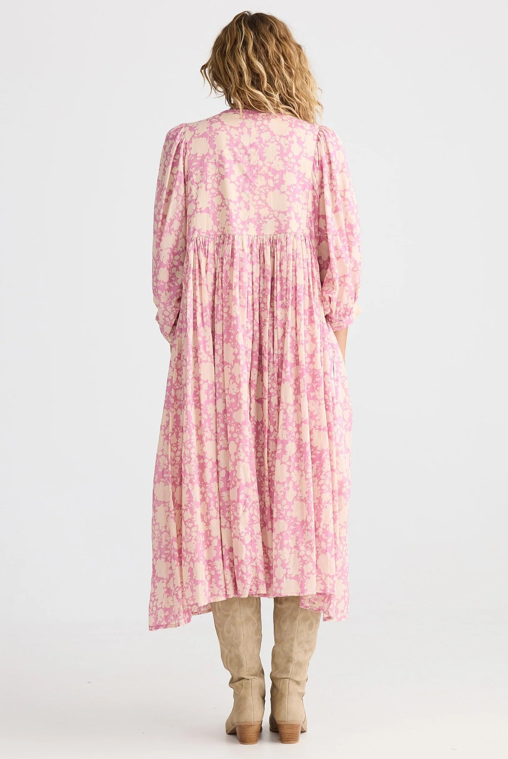 Woman wearing a pink floral dress with a white background