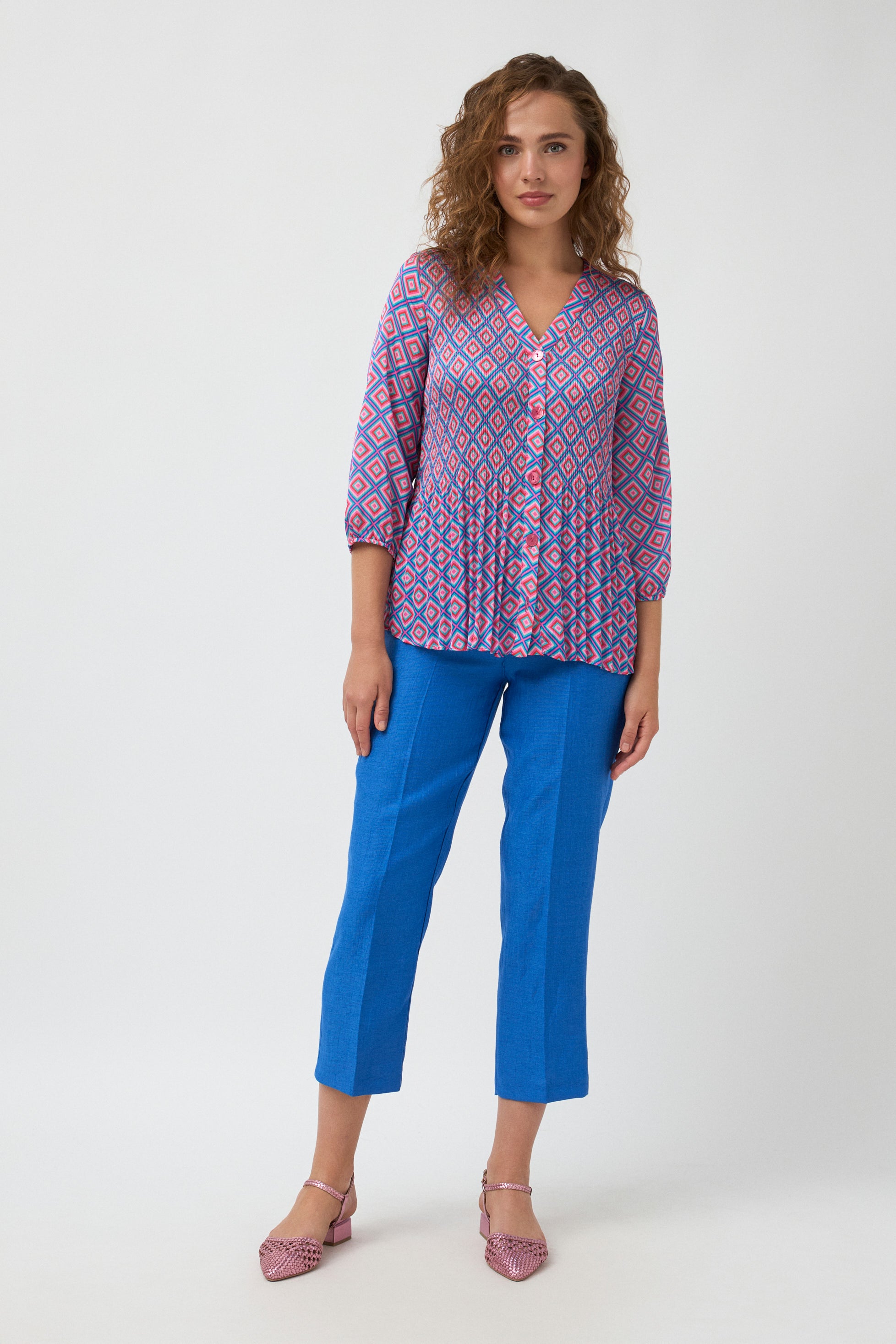 geometric print blouse in pink and blue and blue pants worn by model