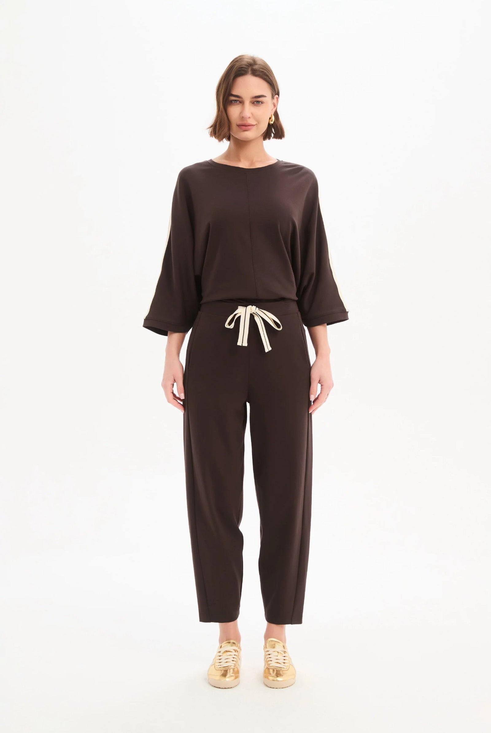 Woman wearing a brown outfit with a white background