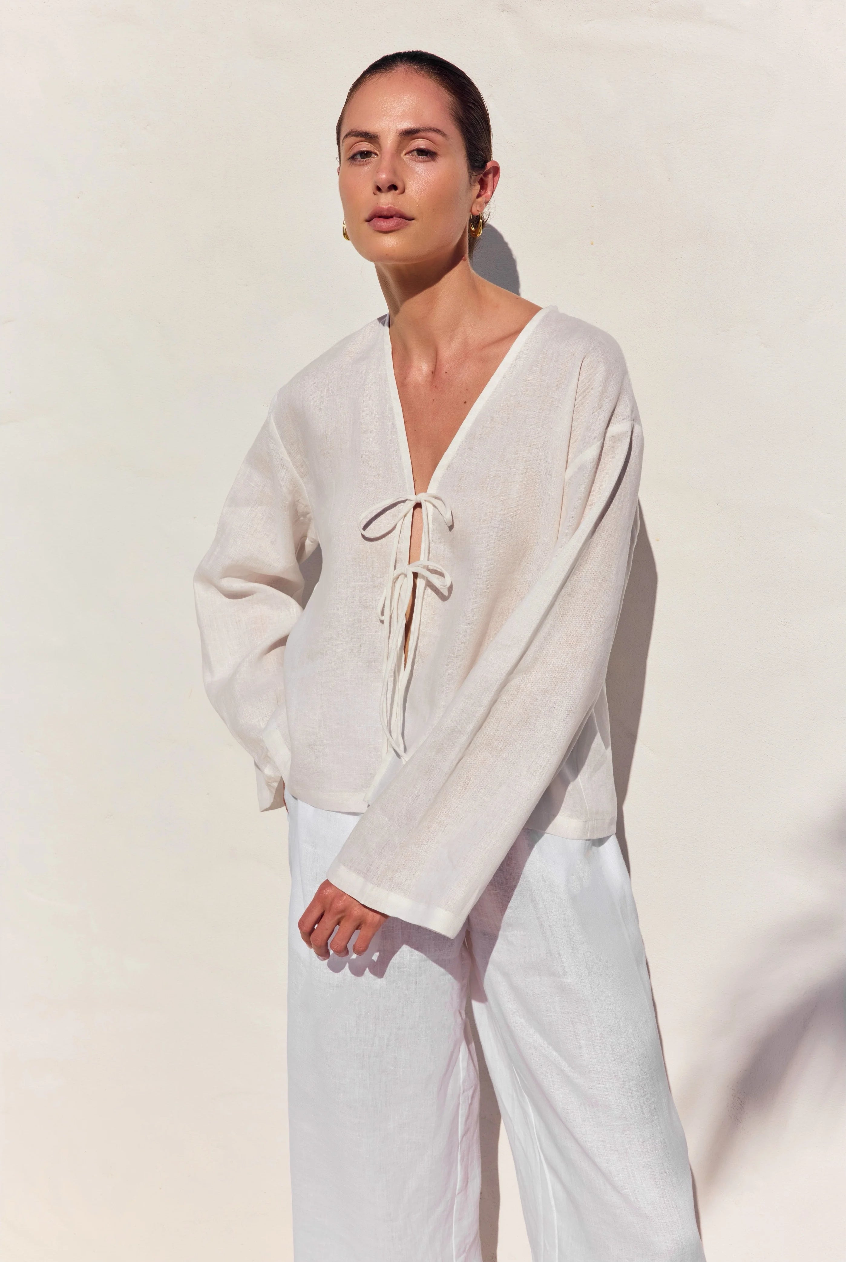 Woman wearing a white outfit with a plain background