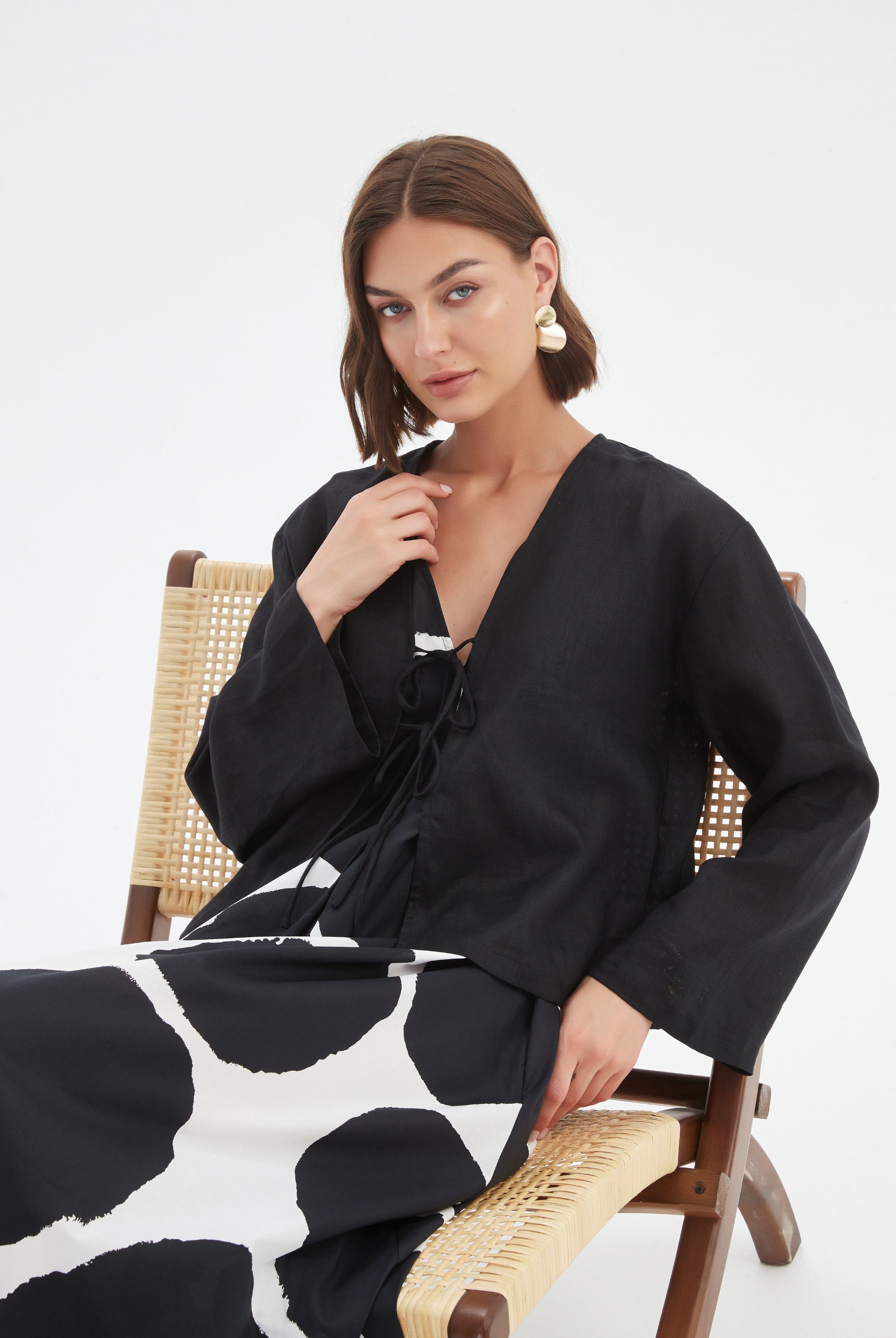 black long sleeve tie front top in black with print dress worn by model