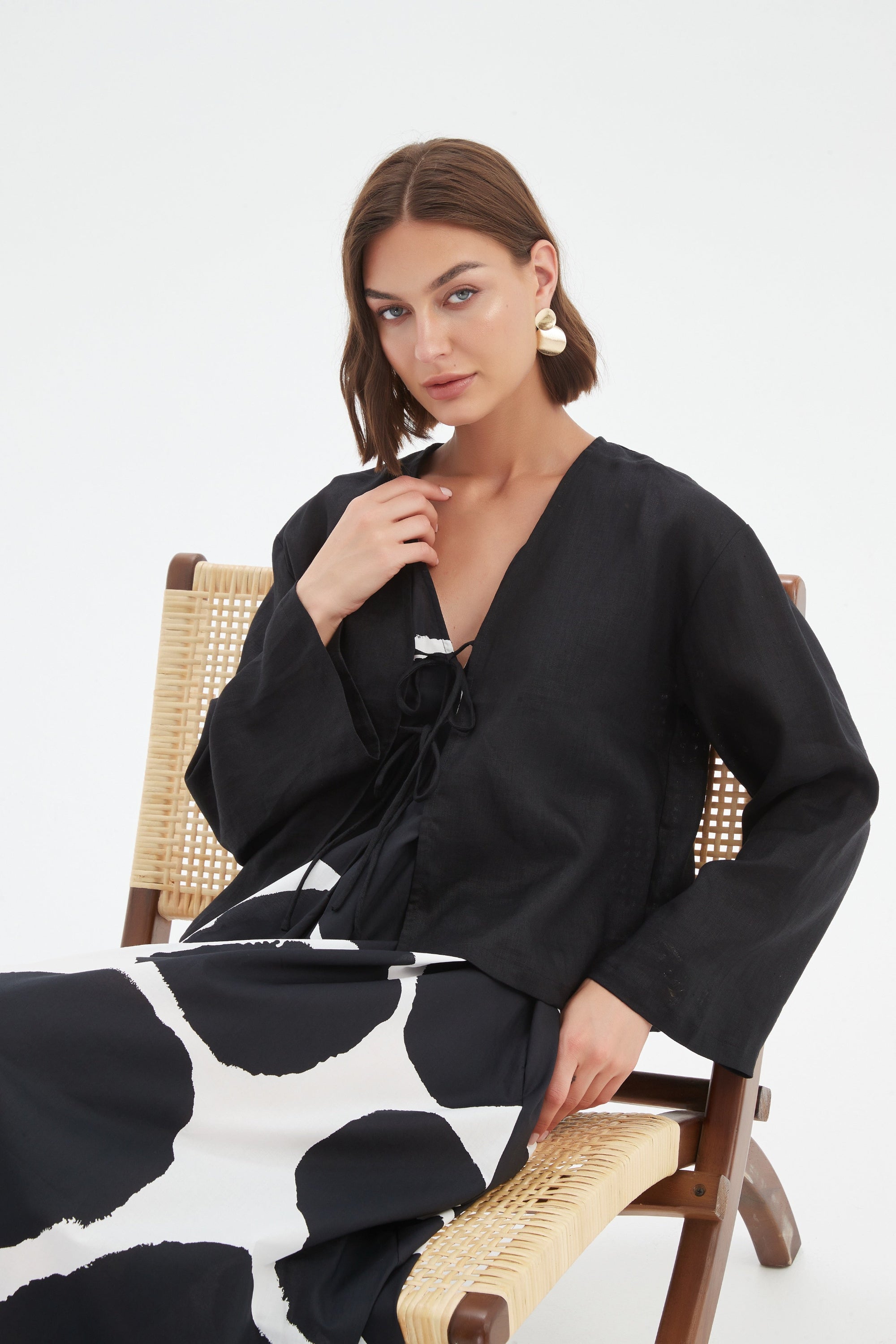 black long sleeve tie front top in black with print dress worn by model