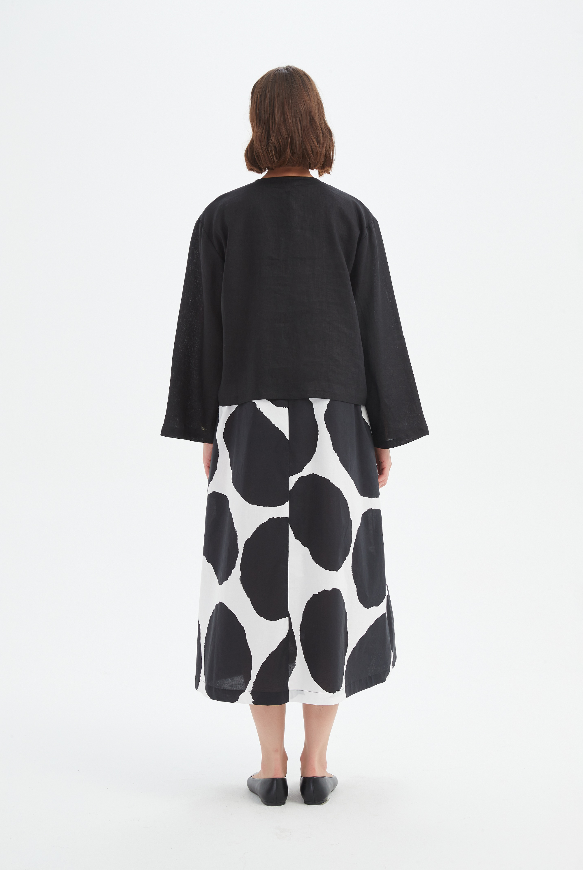 black long sleeve tie front top in black with print dress worn by model back view