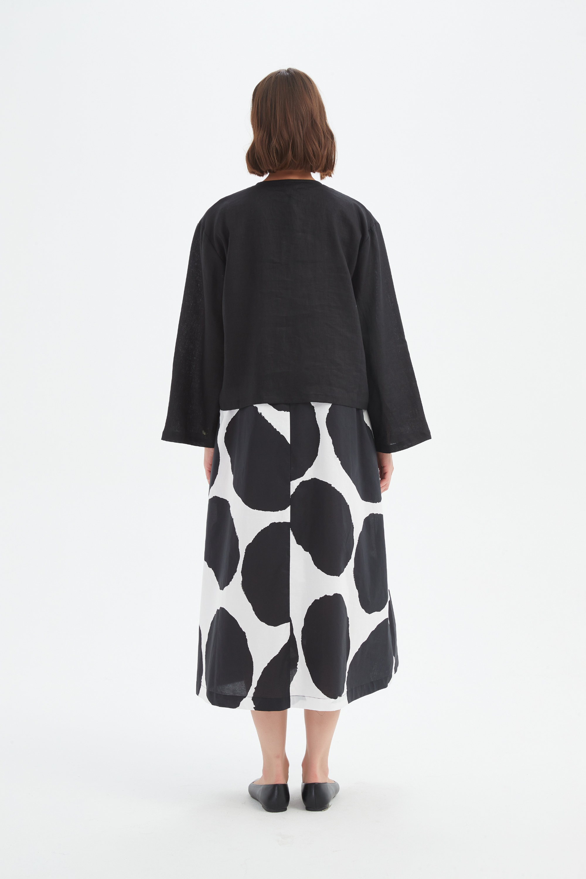 black long sleeve tie front top in black with print dress worn by model back view