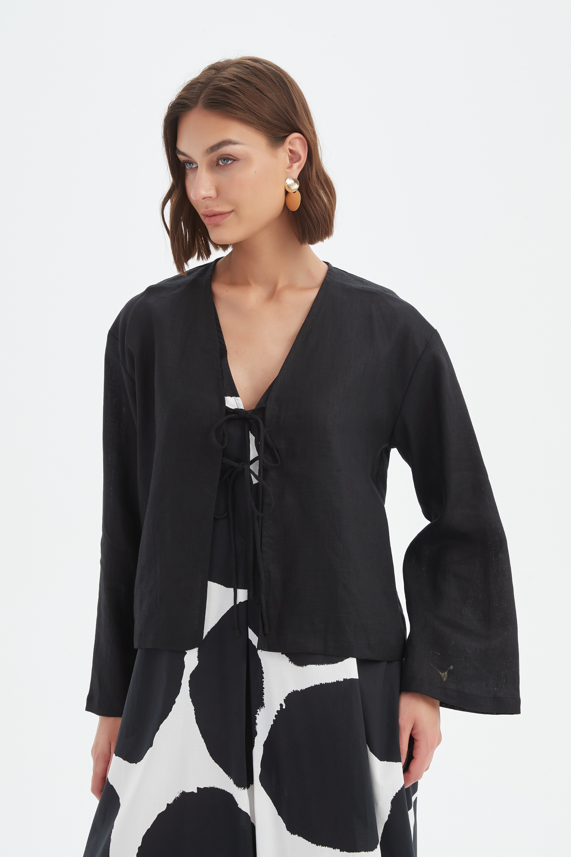 black long sleeve tie front top in black with print dress worn by model