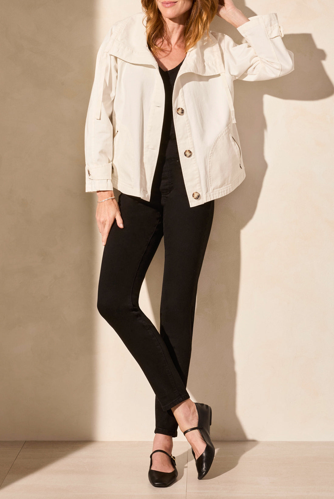 light coat jacket in white un buttoned with black pants worn by model