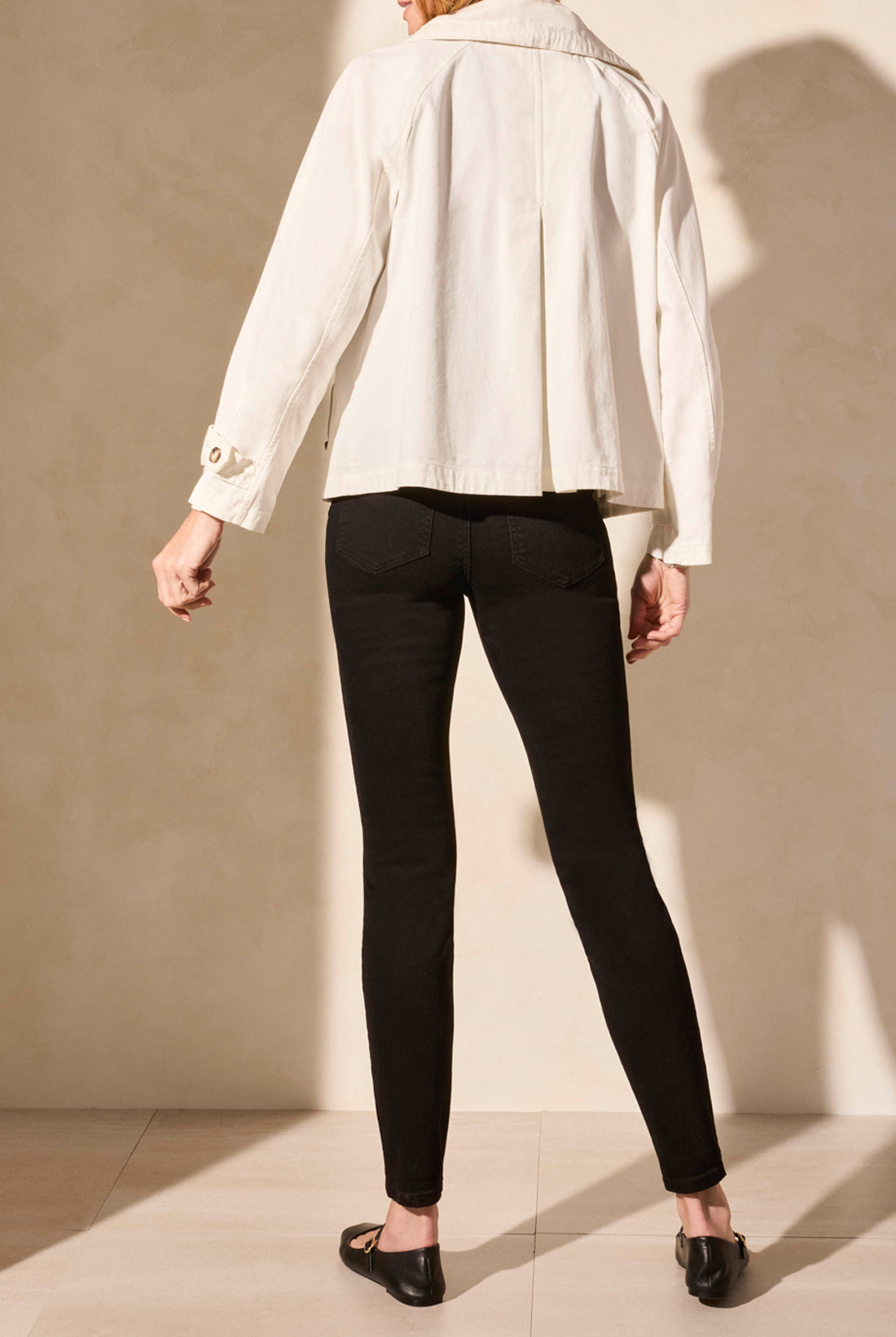 light coat jacket in white with black pants worn by model back view