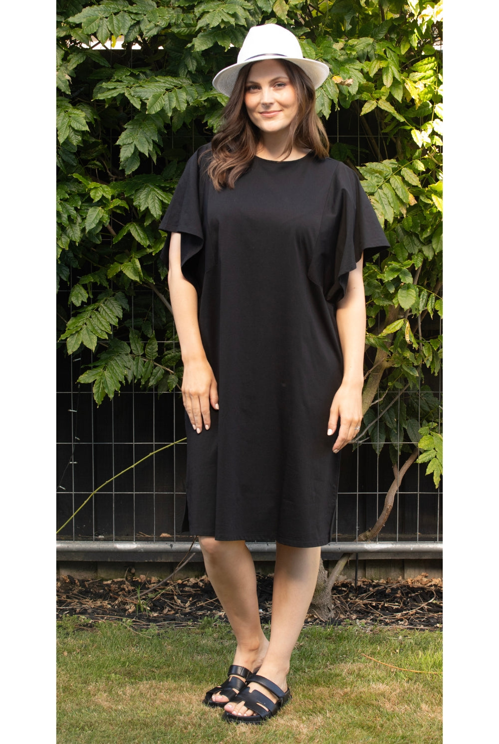 womens kne length midi black dress with flutter sleeves worn by model