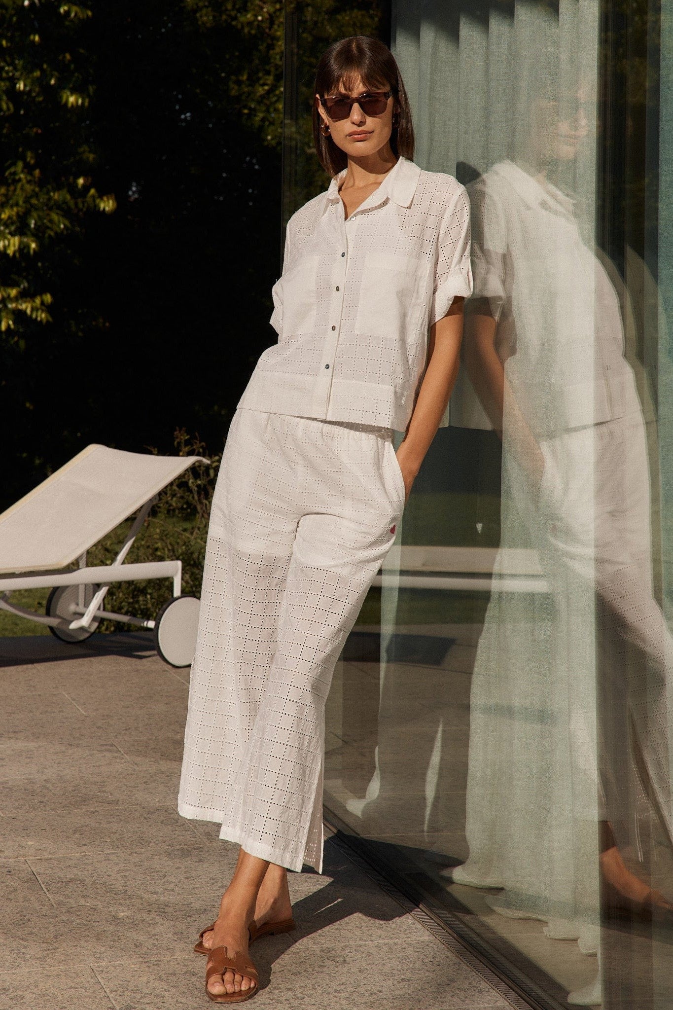 Woman in a white outfit standing outdoors with blurred background