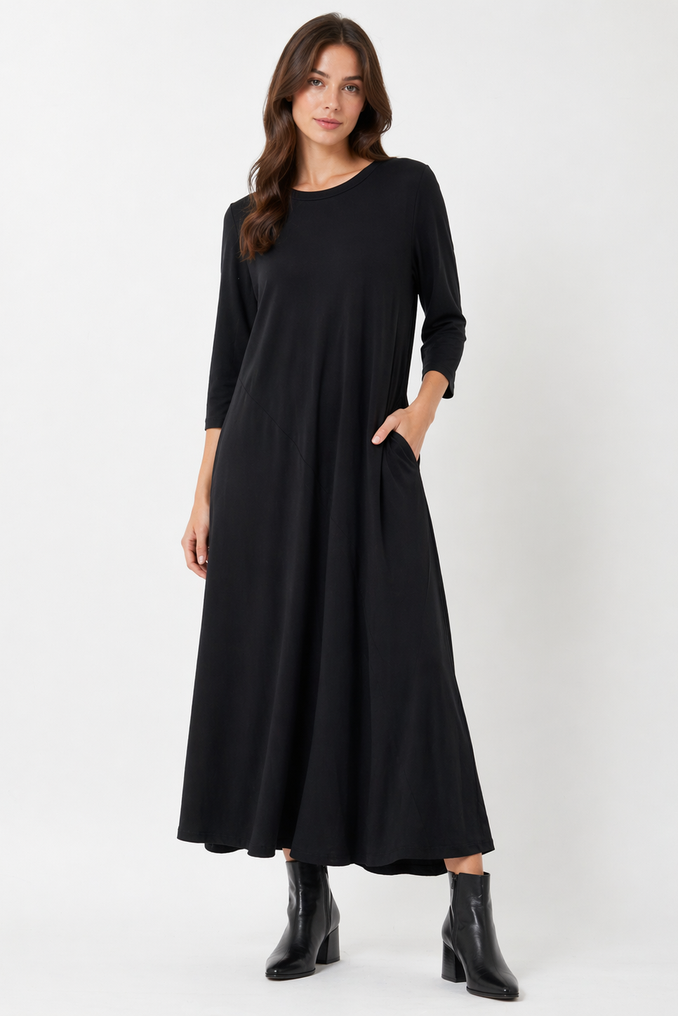 Woman wearing a black dress with long sleeves on a white background