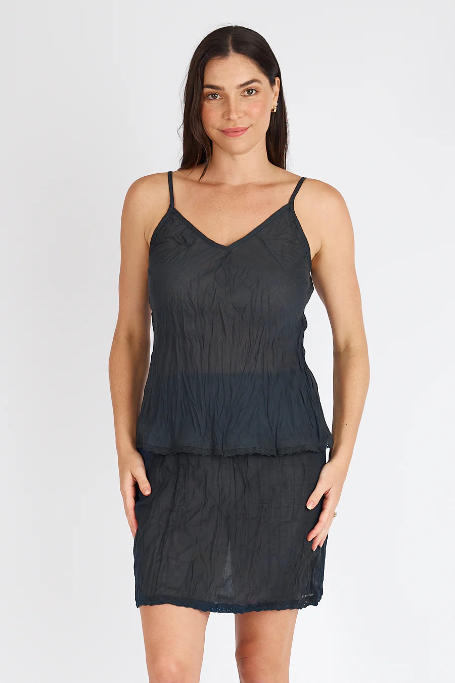 Woman wearing a black layered dress against a white background