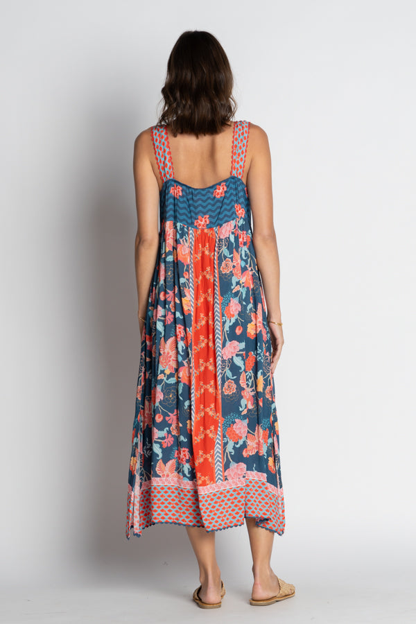 Woman wearing a sleeveless dress with floral pattern on a plain background back view