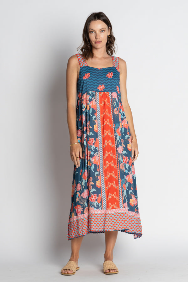 Woman wearing a sleeveless dress with a floral and geometric pattern on a white background