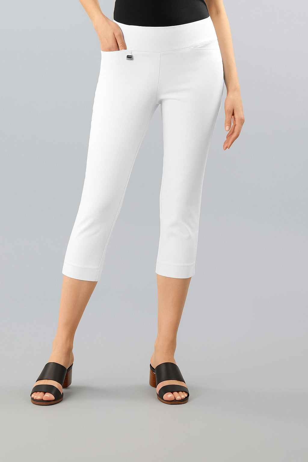 Person wearing white capri pants on a gray background