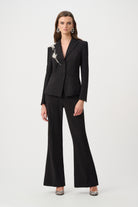 women wearing black blazer with rhinestone applique and black pants on white background