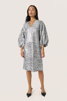 Woman wearing a patterned dress on a white background