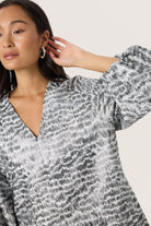 Woman wearing a patterned dress with a neutral background