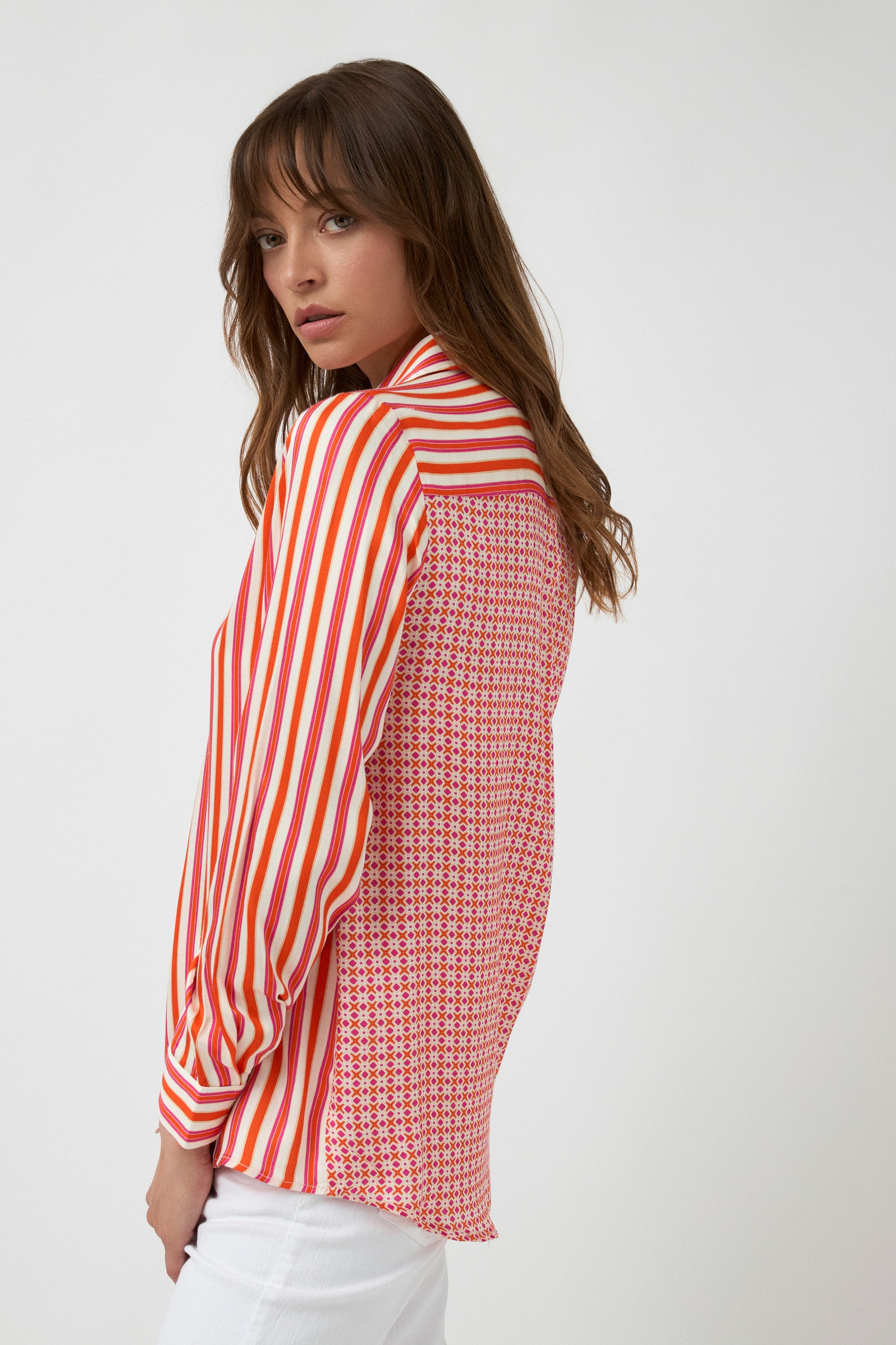 orange pink white stripe button through shirt and white pants worn by model side view