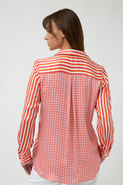orange pink white stripe button through shirt and white pants worn by model back view