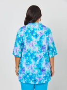 Woman wearing a blue floral blouse against a white background