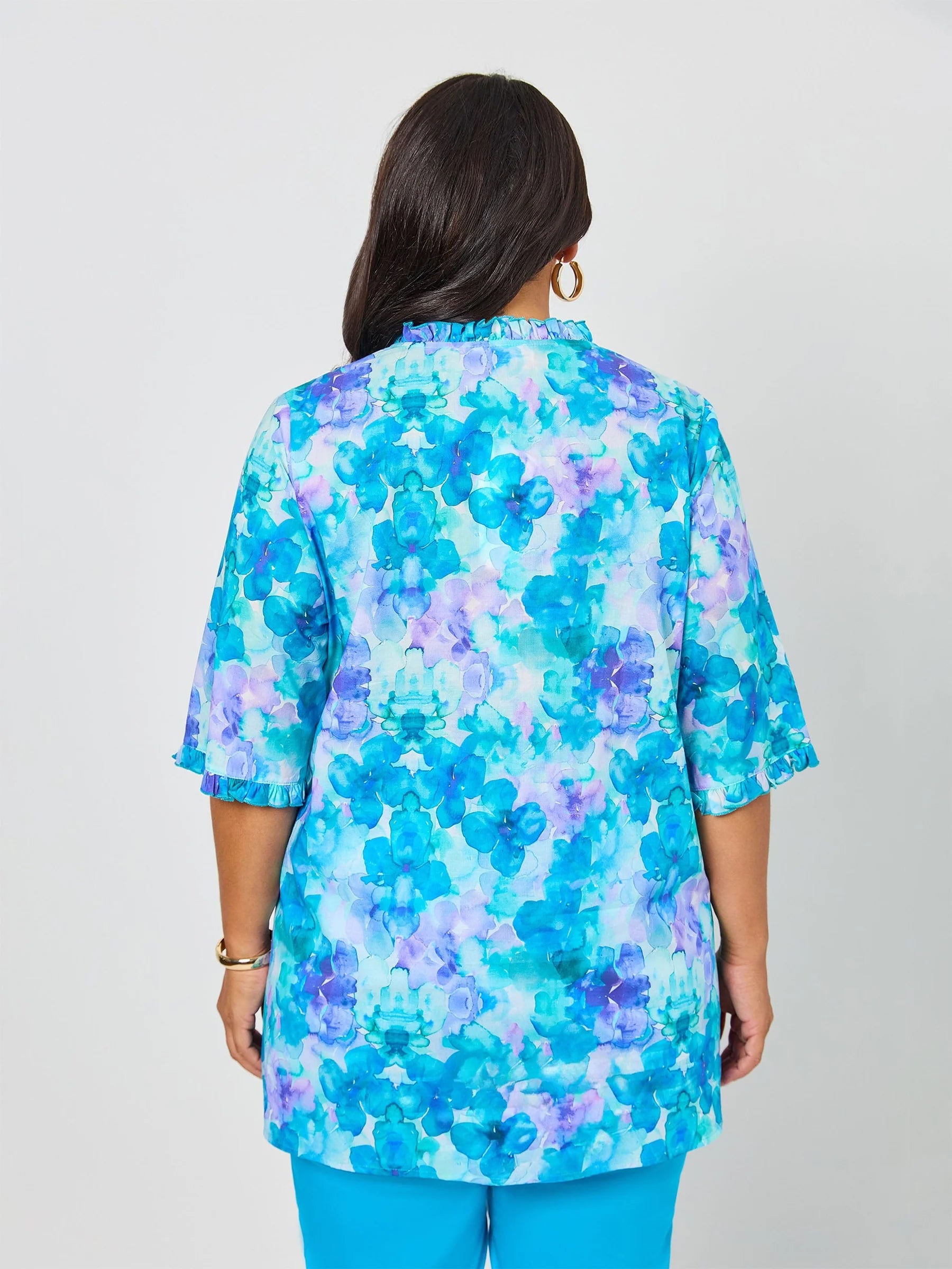Woman wearing a blue floral blouse against a white background