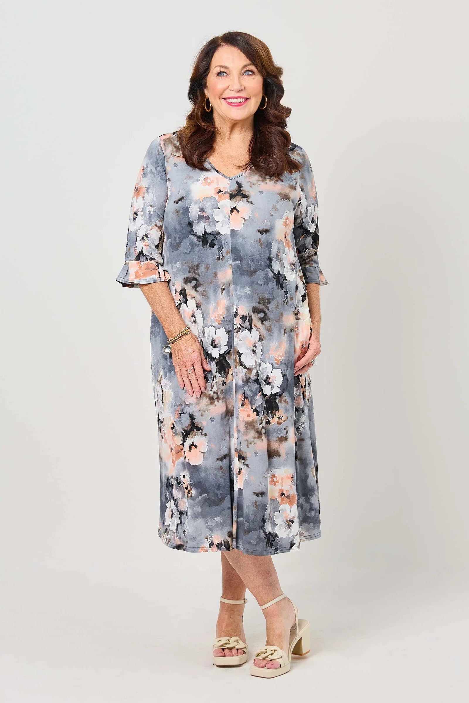 Woman wearing a floral dress on a plain background