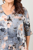 Woman wearing a floral blouse with a neutral background