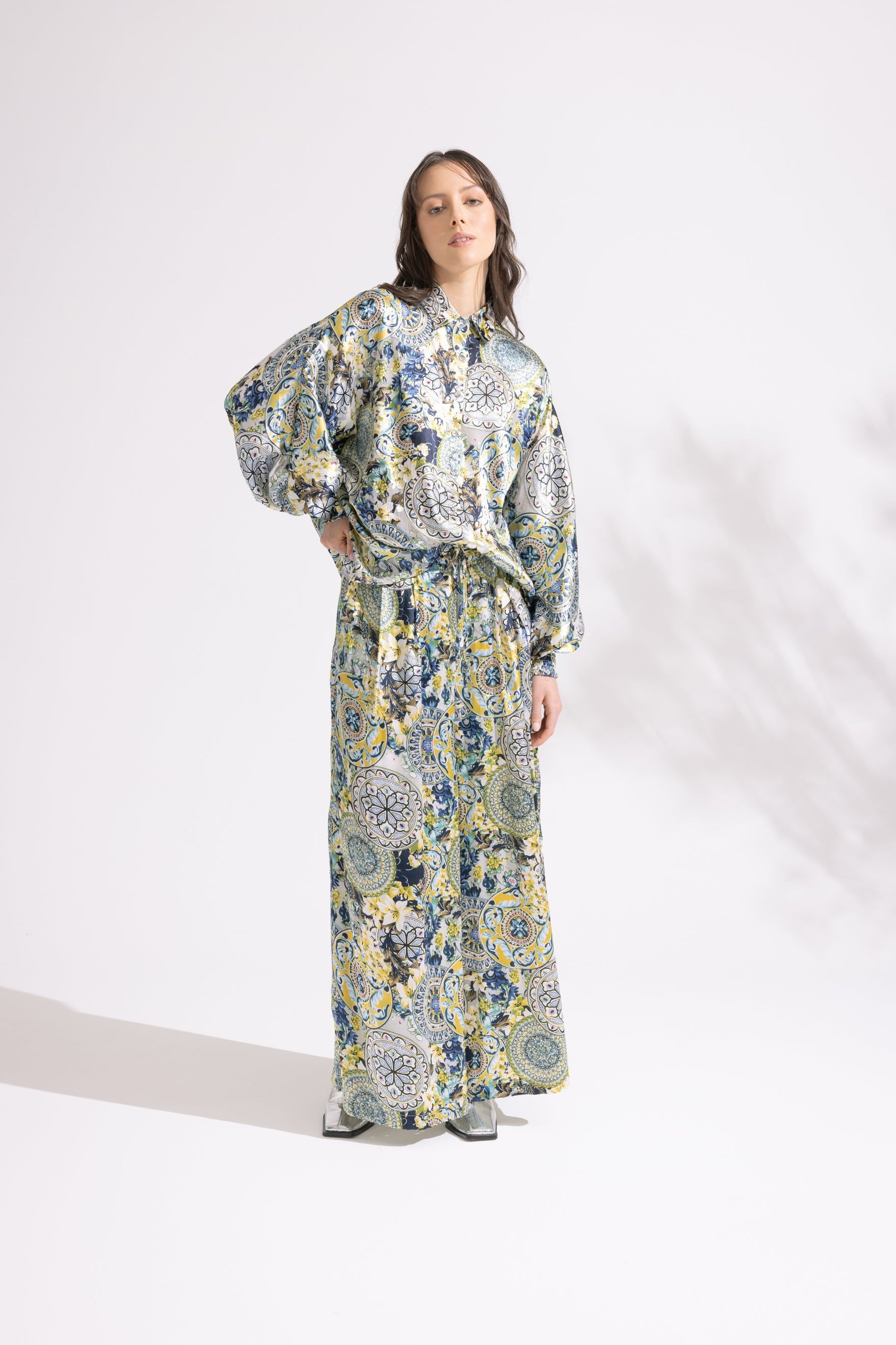 Woman wearing a floral dress and pants set on a white background