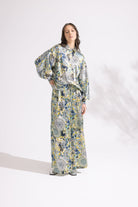 Woman wearing a floral dress and pants set on a white background
