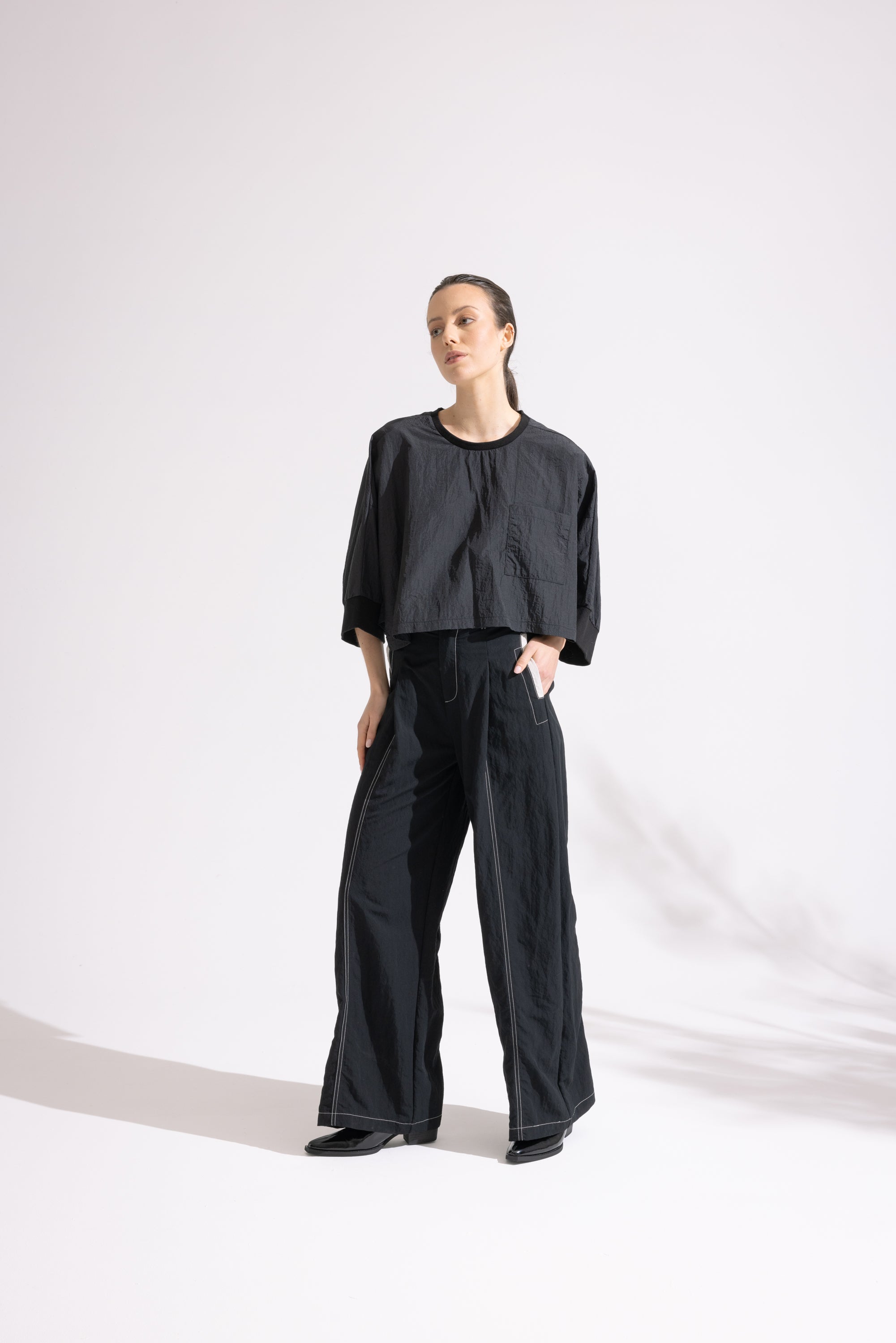 Person wearing a black outfit on a white background