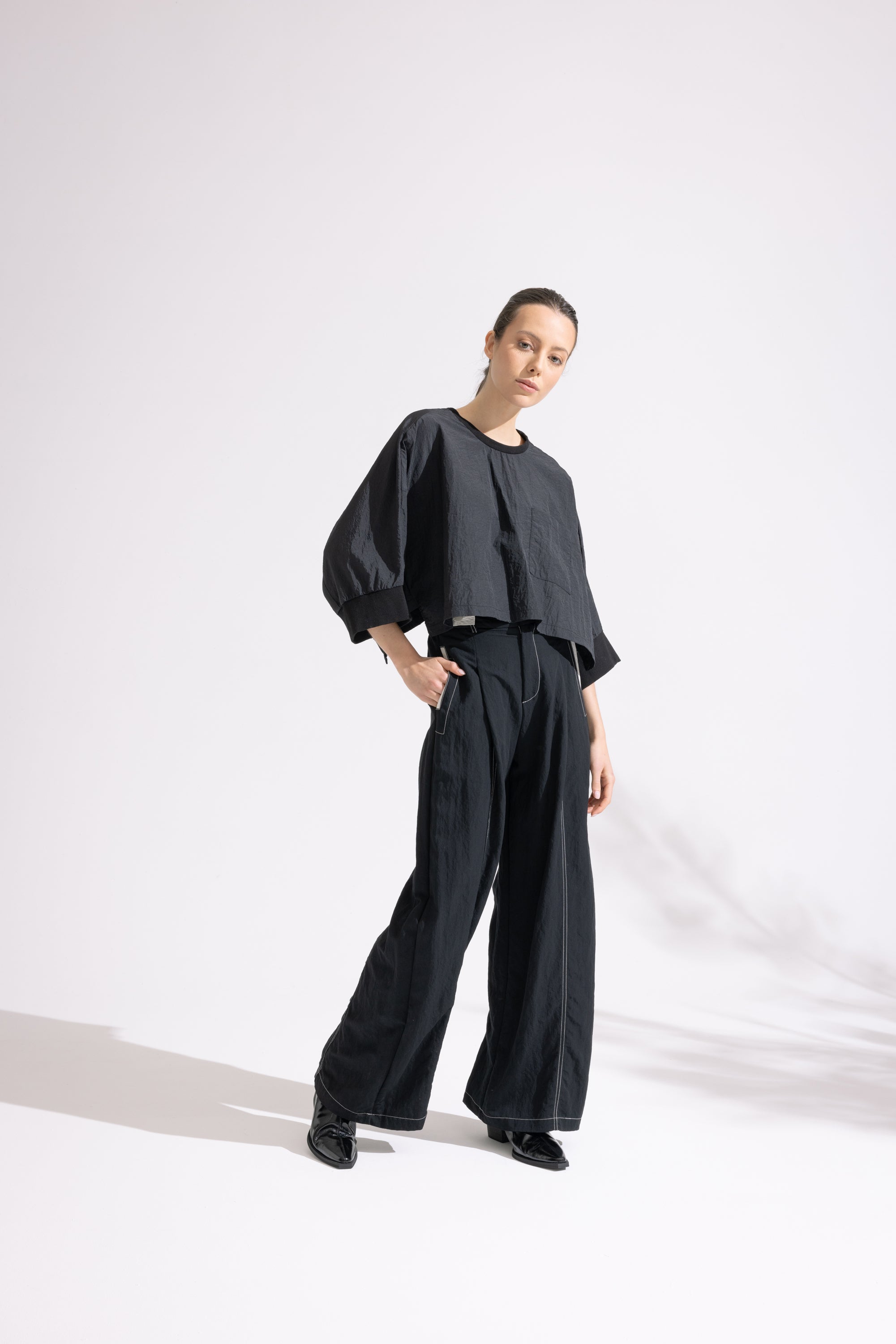 Person wearing a black outfit on a white background