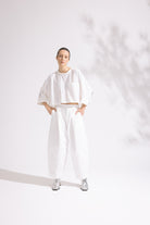 Person wearing a white outfit on a plain background