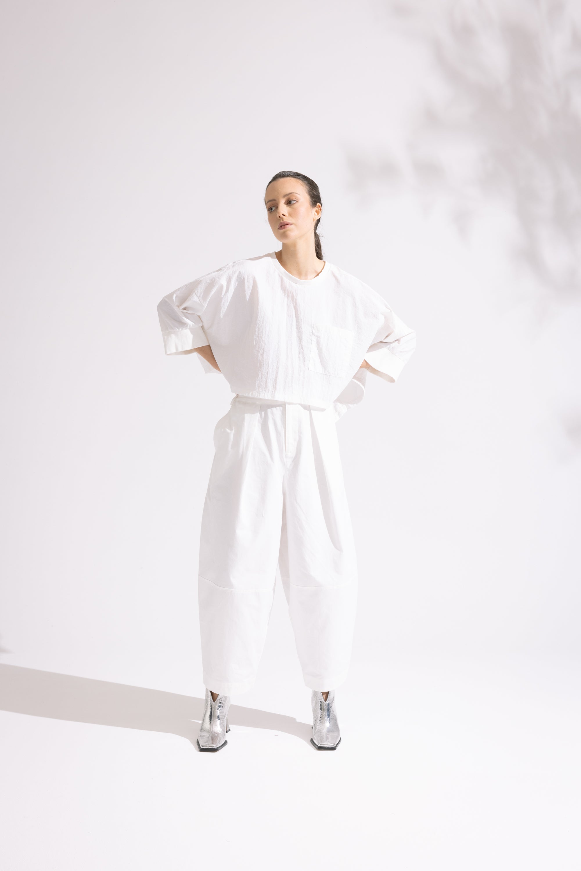 Person wearing a white outfit on a plain background