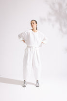 Person wearing a white outfit on a plain background