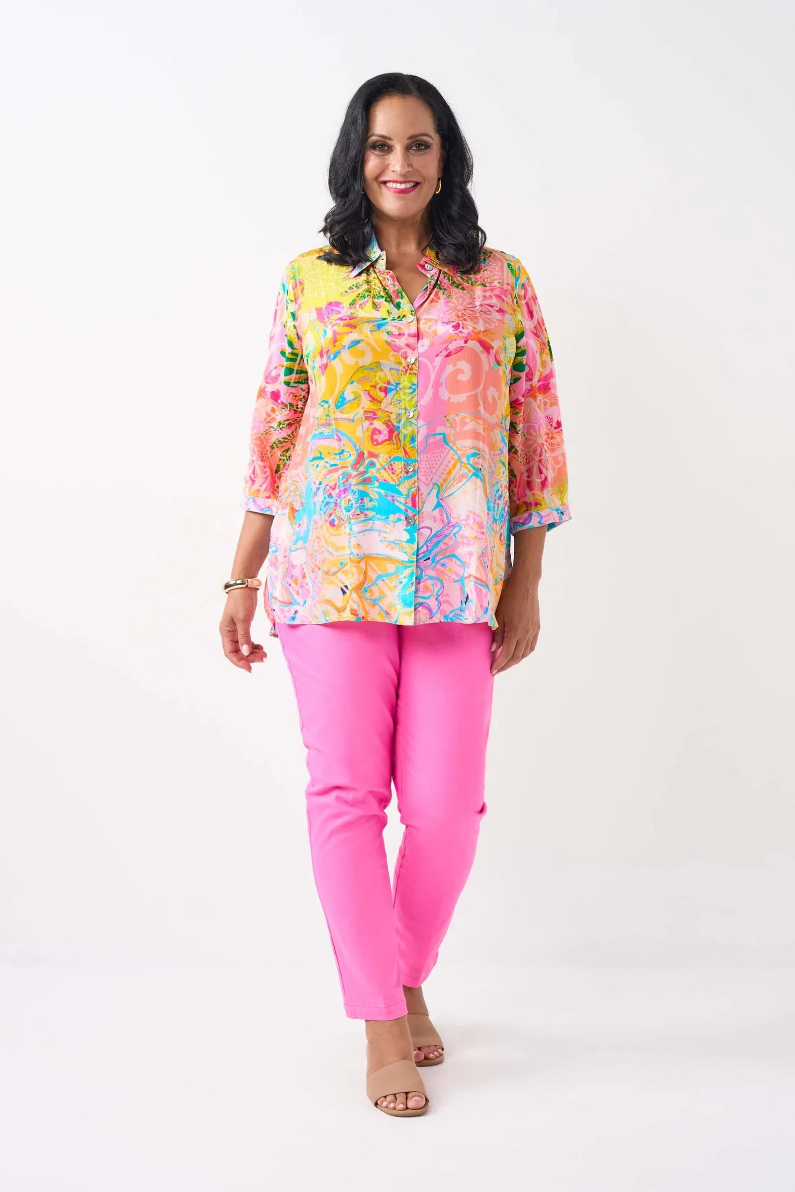 women wearing  a patterned shirt and pink pants on a white background